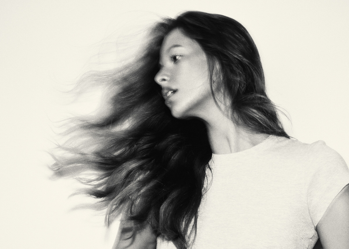 Black-and-white profile portrait of Jess Holiday with her hair moving across the frame