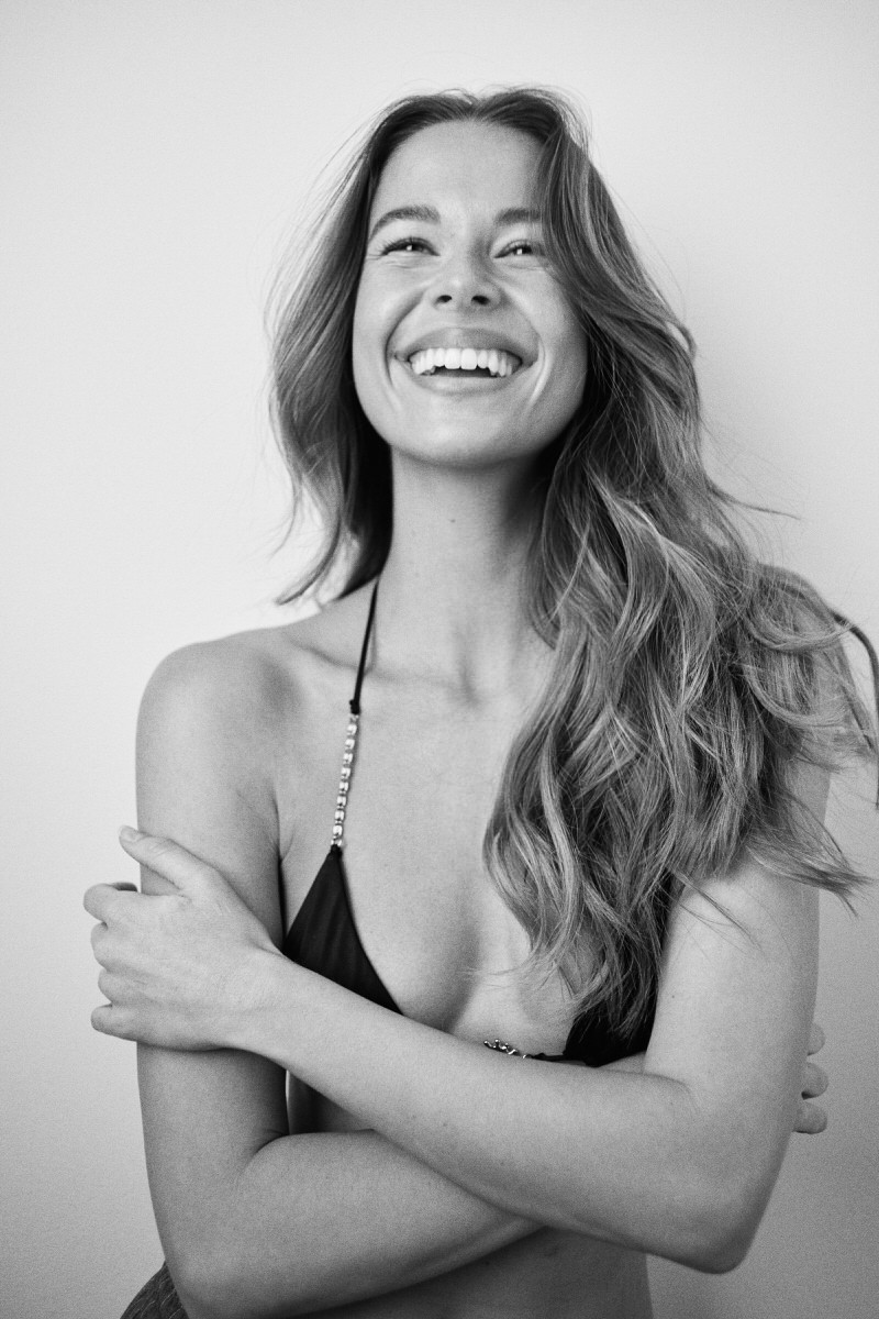 Black-and-white portrait of Jess Holiday smiling with her arms folded
