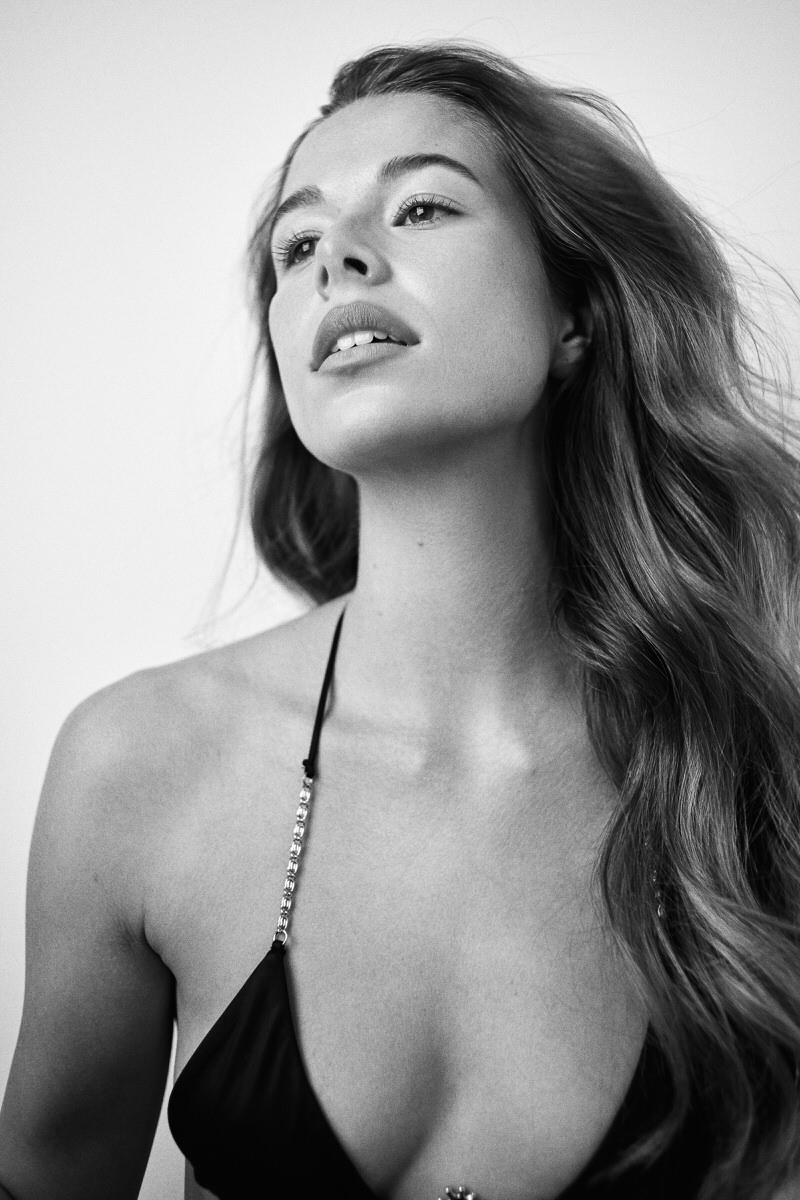 Black-and-white portrait of Jess Holiday looking upward in black swimwear