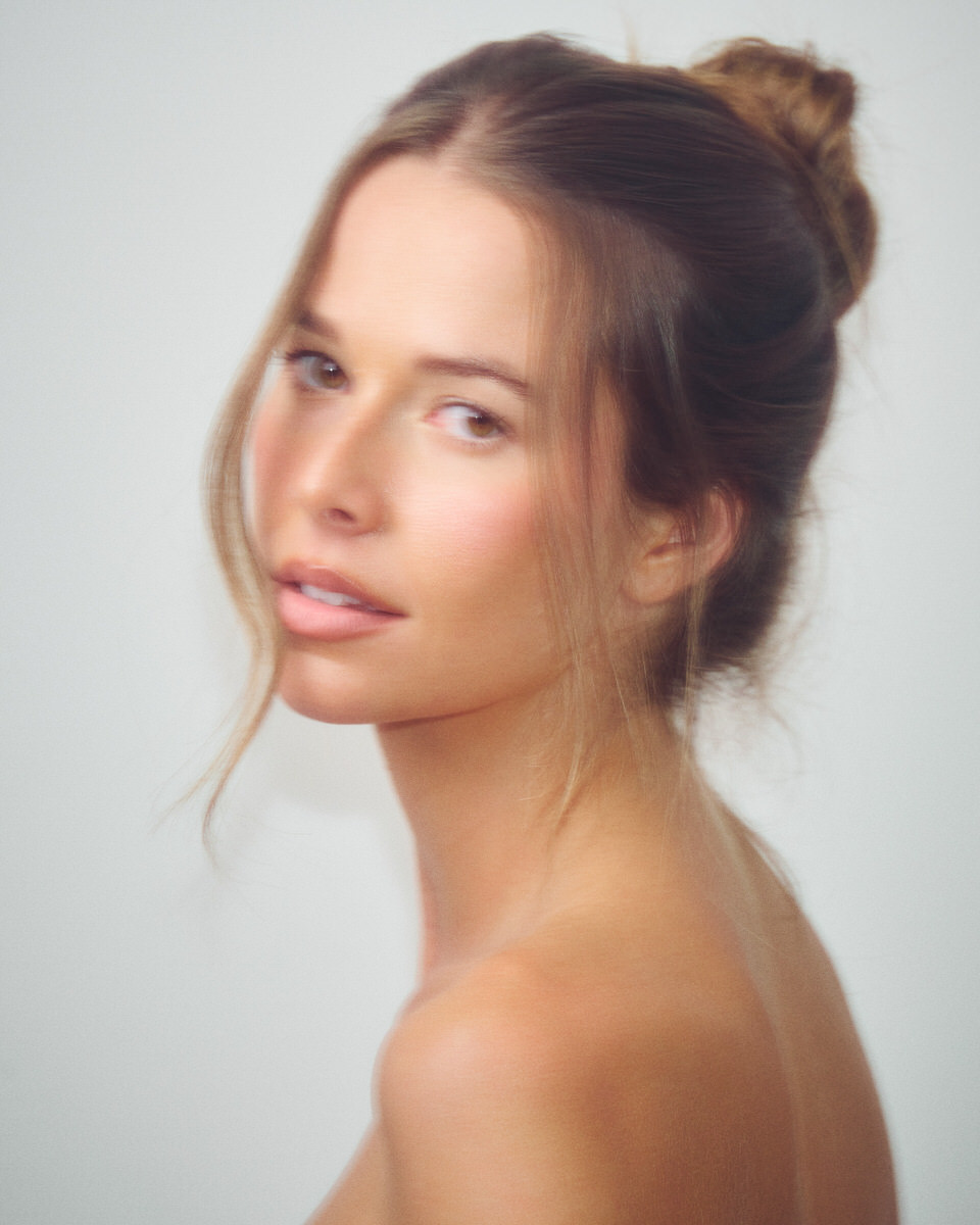 Soft-focus colour portrait of Jess Holiday looking back over her shoulder